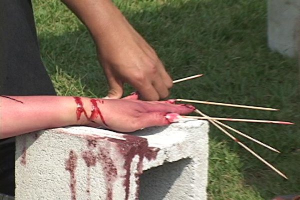 渥太华国会山“酷刑展”现场- 竹签钉指（大纪元摄影）