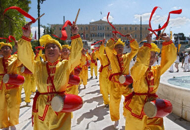 8月11日，約百名法輪功學員在希腊雅典舉行游行。據悉法輪功是奧運期間唯一被允許在雅典遊行的團體。圖為法輪功學員的腰鼓隊。（法新社圖片〕