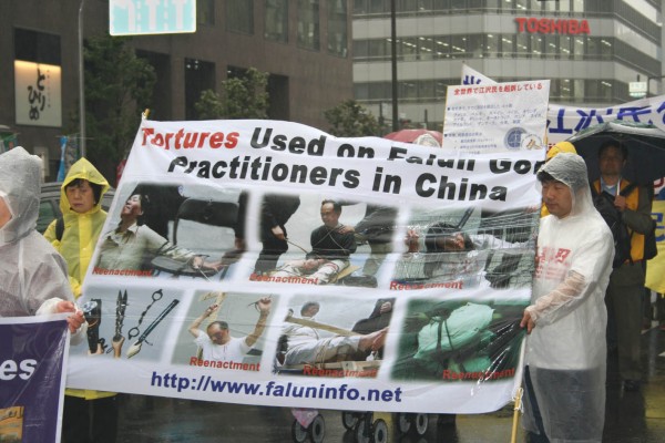图：日本法轮功学员在游行中展示再现中国对法轮功学员的酷刑图片（大纪元）