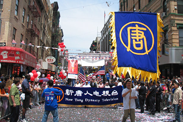 新唐人电视台的队伍以一面巨大的“唐”字大旗引导。