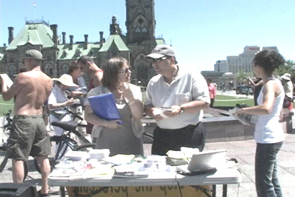 7月20日加拿大首都国会广场，游客关注法轮功受迫害真象（大纪元摄影）