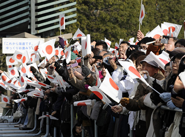 2012年1月2日，參加民眾揮舞日本國旗。（AFP PHOTO / TOSHIFUMI KITAMURA）