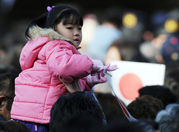 2012年1月2日，一位日本小女孩隨大人參加活動。（AFP PHOTO / TOSHIFUMI KITAMURA）  