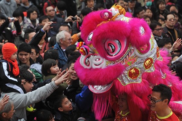 2012年1月27日，香港，民众伸手触摸舞狮，期盼带来好运（aaron tam/AFP） 