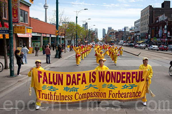 多伦多庆祝法轮大法日大游行，图为腰鼓队经过唐人街。（摄影：艾文/大纪元）