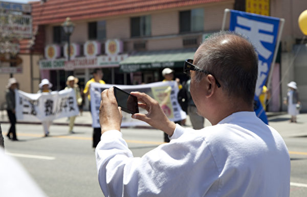2012年5月27日，法轮功学员在洛杉矶中国城举行盛大的“庆祝法轮大法洪传20周年暨声援1亿1千6百万三退”集会游行活动。路人观看游行。（摄影：季媛/大纪元）

