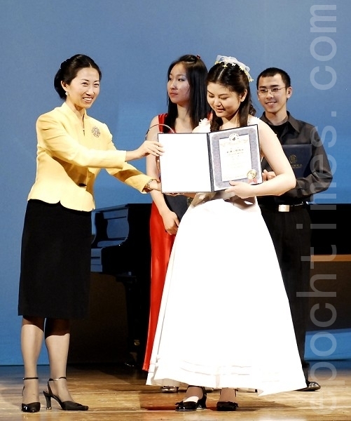 2008年新唐人全球系列大賽組委會主席馬麗娟為全世界華人鋼琴大賽銀獎得主蓮娜頒發獎金和獎狀。（攝影：戴兵/ 大紀元）