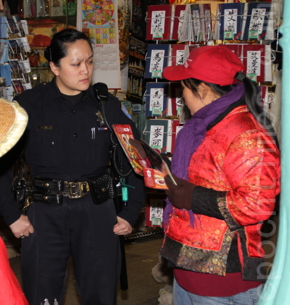 旧金山女警员T.O，正在听取袭击大纪元记者的新杏香传单女的陈词。（摄影：曾文彪/大纪元）