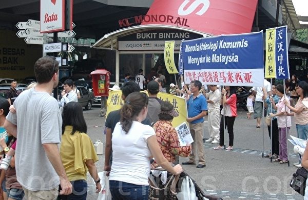 馬來西亞退黨服務中心在吉隆玻車水馬龍的武吉免登街頭聲援三退勇士，引起許多民眾的關注。（攝影：楊曉慧/大紀元）