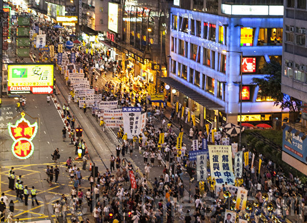 法輪功學員的遊行陣列，呼籲中國民眾退出中共黨、團、隊，解體中共。（攝影：余鋼／大紀元）