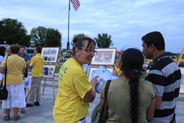2012年7月13日，美國華盛頓DC二戰紀念碑前，法輪功真相圖片展的現場，民眾正在聽法輪功學員講真相。（攝影：李明／大紀元）