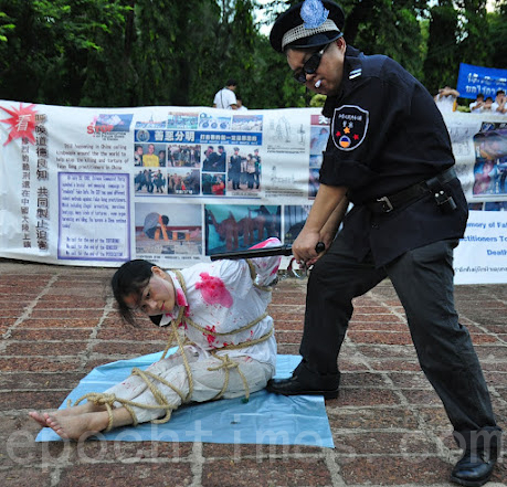  法轮功学员演示中共酷刑，抗议中共迫害。 (摄影：万全顺/大纪元)