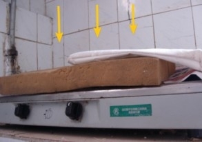 煤氣灶已無法使用，平時鋪著報紙編織袋接流下來的屎尿湯（這是清掃後拍攝的情形）（圖片來源：明慧網）