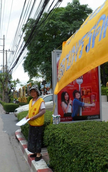 泰国曼谷中共大使馆前，一位72岁的泰籍华人老太太还是一如既往地每周五天准时在对面马路拉横幅抗议中共对中国法轮功学员的残酷迫害。在7月18日，还换上了一条更大更长的新横幅。（摄影：史丹云/大纪元）
