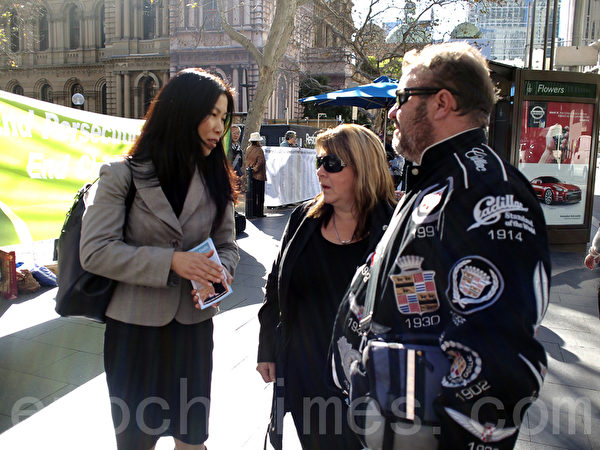 7月20日，在悉尼市政厅广场，悉尼法轮功学员为纪念“7•20”法轮功反迫害13周年打出各种横幅，图为澳洲人来了解真相。（摄影：伊罗逊/大纪元）     