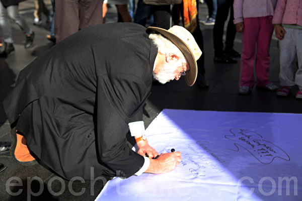 7月20日，在悉尼市政廳廣場，悉尼法輪功學員為紀念「7•20」法輪功反迫害13週年舉辦集會活動。圖為澳洲民眾簽名聲援法輪功，要求停止迫害。（攝影：袁麗/大紀元）