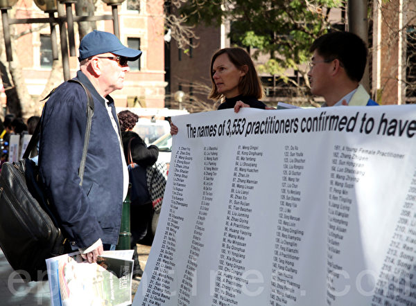 7月20日，在悉尼市政廳廣場，悉尼法輪功學員為紀念「7•20」法輪功反迫害13週年打出各種橫幅，圖為澳洲人來瞭解真相。（攝影：袁麗/大紀元） 