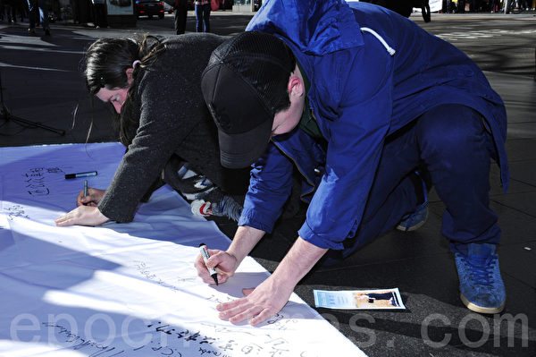 7月20日，在悉尼市政廳廣場，悉尼法輪功學員為紀念「7•20」法輪功反迫害13週年舉辦集會活動。圖為澳洲民眾簽名聲援法輪功，要求停止迫害。（攝影：簡玬/大紀元）