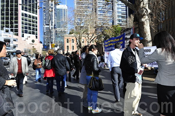 7月20日，在悉尼市政廳廣場，悉尼法輪功學員為紀念「7•20」法輪功反迫害13週年打出各種橫幅，圖為澳洲民眾來瞭解真相。（攝影：簡玬/大紀元） 