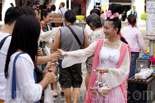 遊行隊伍還有法輪功女學員穿著仙女服飾，傳遞法輪大法的真相資料和小卡片，受到路人的喜愛。（攝影：吳柏樺／大紀元）