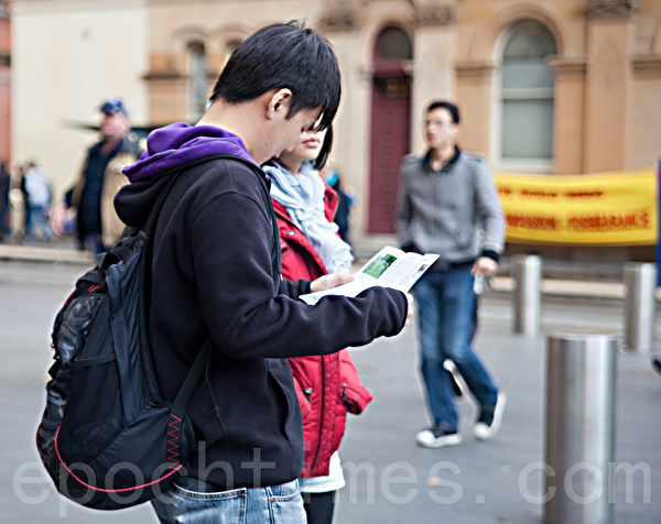 7月22日周日，悉尼法轮功学员来到悉尼市中心，举行“7•20”法轮功学员反迫害大练功、讲真相活动。图为了解真相的华人。（摄影：袁丽/大纪元）