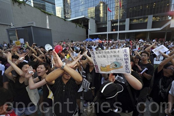 遊行人士在政府總部外以手勢表達不要洗腦國民教育。（攝影：潘在殊/大紀元）