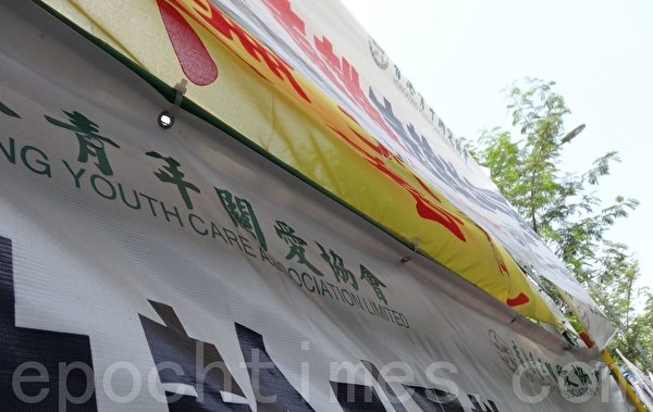 中港邊境落馬洲，中共惡黨團夥「香港青年關愛協會」用橫幅包圍遮蓋法輪功的橫幅。（市民提供）