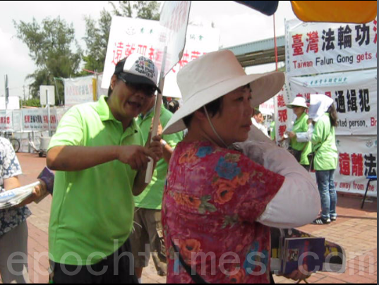 今年9月10日，青關會成員在落馬洲黃巴站手持汙衊法輪功橫幅，出言挑釁善良的法輪功學員。（市民提供）
