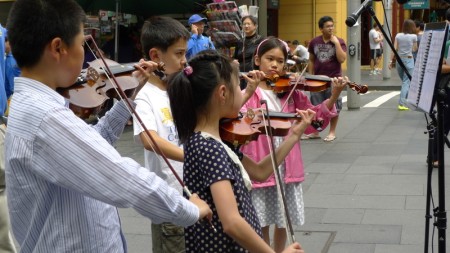 12月2日中午，在悉尼市中心的乔治大街近唐人街的地方，举行了声援中国大陆近一亿3千万“三退”人士的集会活动。明慧小学的学生在表演小提琴乐曲。（摄影：简玬/大纪元）