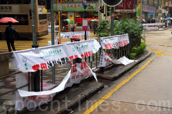 11月27日凌晨，在佐敦道与弥敦道交界一带，恶党团伙“香港青年关爱协会”的非法横幅被不知名的市民清剿。（摄影：潘在殊／大纪元）