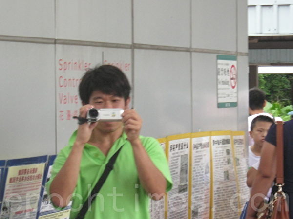 在曾庆红、梁振英授意下，青关会雇佣配备专业摄影器材来滋扰香港法轮功真相点的帮凶。（大纪元图片）