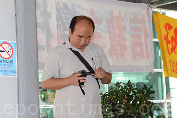 在曾慶紅、梁振英授意下，青關會雇傭配備專業攝影器材來滋擾香港法輪功真相點的幫兇。（大紀元圖片）