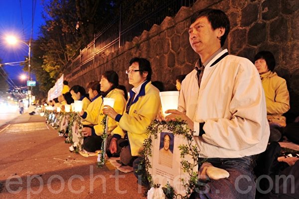 　　2013年4月25日晚，大温哥华地区部分法轮功学员在中领馆前集会，纪念法轮功学员4.25和平上访14周年，要求法办江泽民集团。右一为张忠余先生。 （摄影：景浩/大纪元） 