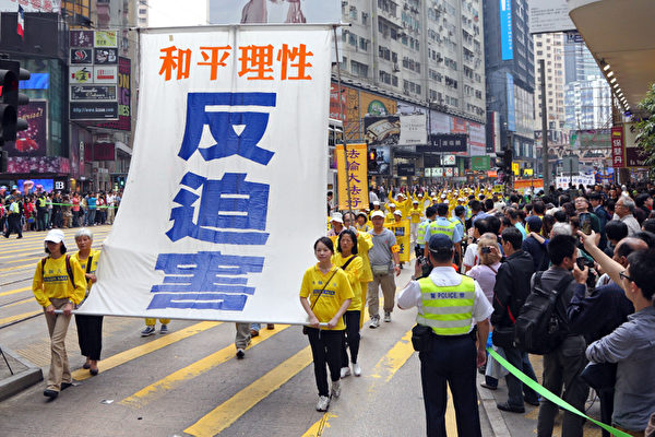 香港法轮功学员4月28日举行反迫害集会游行，纪念425和平大上访14周年，游行队伍途径港岛的闹市区，气势磅礡的阵势吸引大批中港民众观看。（摄影：潘在殊/大纪元）
