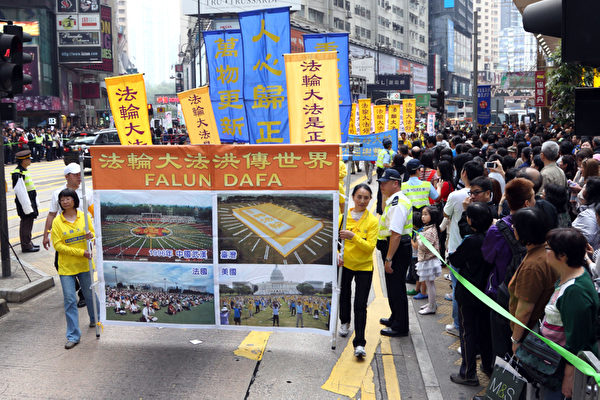 香港法輪功學員4月28日舉行反迫害集會遊行，紀念425和平大上訪14周年，遊行隊伍途徑港島的鬧市區，氣勢磅礡的陣勢吸引大批中港民眾觀看。（攝影：潘在殊/大紀元）
