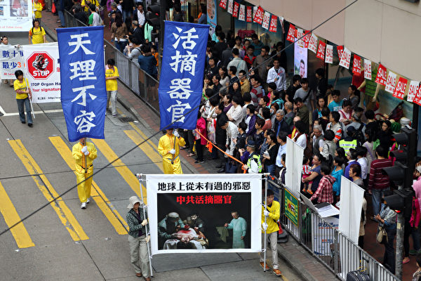 香港法轮功学员4月28日举行反迫害集会游行，纪念425和平大上访14周年，游行队伍途径港岛的闹市区，气势磅礡的阵势吸引大批中港民众观看。（摄影：潘在殊/大纪元）
