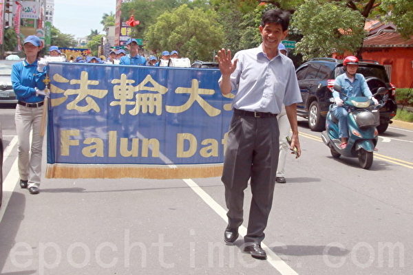 走入踩街活动队伍中一起游行，以实际行动支持法轮功的台南市议员李文正。（摄影：赖友容／大纪元）