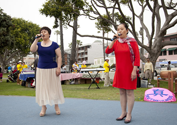 5月12日，来自大洛杉矶地区的上百名法轮功学员在南加州旅游胜地圣塔莫妮卡海滩隆重庆祝世界法轮大法日。学员表演女声小合唱。（摄影：季媛/大纪元）