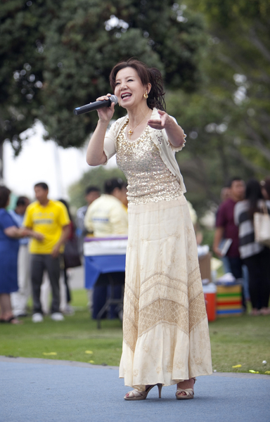 5月12日，来自大洛杉矶地区的上百名法轮功学员在南加州旅游胜地圣塔莫妮卡海滩隆重庆祝世界法轮大法日。学员表演女声独唱。（摄影：季媛/大纪元）