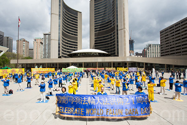 5月13日，数百名法轮功学员及民众在多伦多市政广场庆祝法轮大法传世21周年。图为法轮功学员在集体炼功。（摄影：艾文/大纪元）