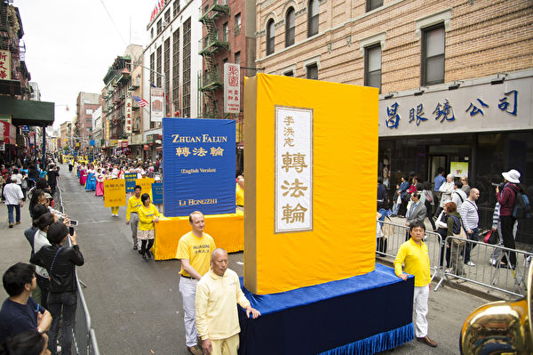 2013年5月18日，紐約曼哈頓，來自世界各地的法輪功學員在此舉行慶祝法輪大法弘傳21週年大遊行。圖為遊行的第一主題「大法洪傳」方陣。圖為《轉法輪》大型書模型。（戴兵／大紀元）