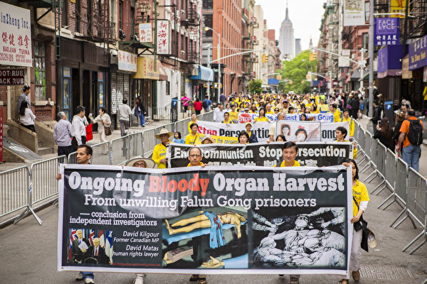 5月18日的纽约曼哈顿，来自世界各地的法轮功学员举行庆祝法轮大法弘传21周年大游行。图为游行队伍第二主题《千古蒙冤 制止迫害》方阵，揭露中共活摘器官暴行的横幅。（摄影：爱德华/大纪元）
