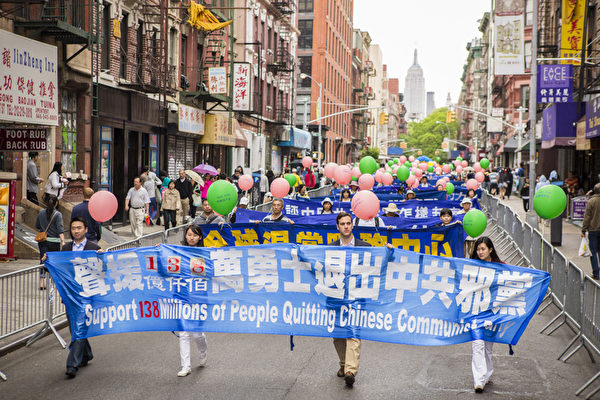 5月18日的纽约曼哈顿，来自世界各地的法轮功学员举行庆祝法轮大法弘传21周年大游行。图为游行队伍第三主题《三退保平安》方阵，声援退党的横幅。（摄影：爱德华/大纪元）