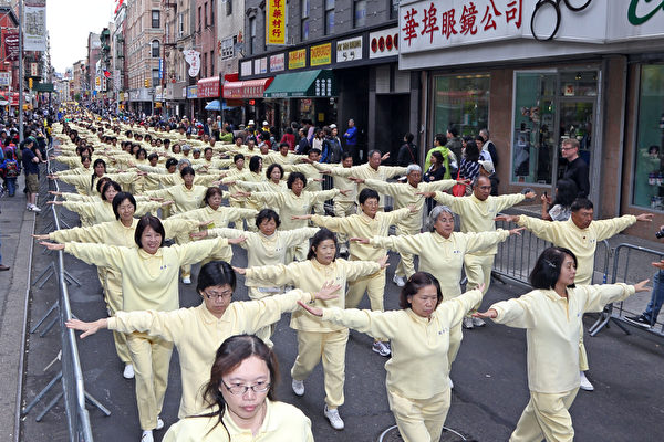 2013年5月18日，紐約曼哈頓，來自世界各地的法輪功學員舉行慶祝法輪大法弘傳21週年大遊行。圖為遊行的第一主題「大法洪傳」方陣中的功法表演隊伍。（潘在殊／大紀元）