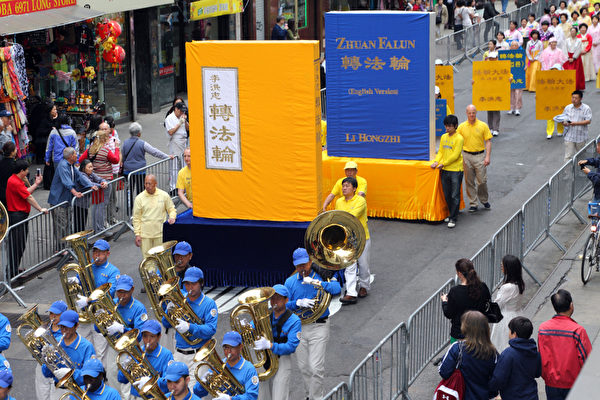 2013年5月18日，紐約曼哈頓，來自世界各地的法輪功學員在此舉行慶祝法輪大法弘傳21週年大遊行。圖為遊行的第一主題「大法洪傳」方陣中的《轉法輪》大模型。（潘在殊／大紀元）