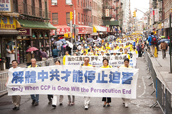 2013年5月18日，紐約曼哈頓，來自世界各地的法輪功學員舉行慶祝法輪大法弘傳21週年大遊行。圖為遊行隊伍中的「三退保平安」方陣，「解體中共才能停止迫害」的橫幅。（戴兵／大紀元）