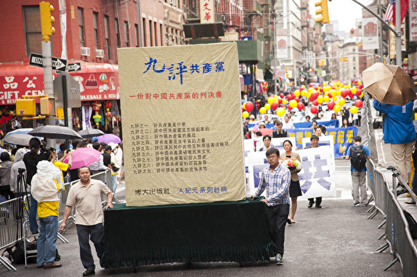 2013年5月18日，紐約曼哈頓，來自世界各地的法輪功學員舉行慶祝法輪大法弘傳21週年大遊行。圖為遊行隊伍中的「三退保平安」方陣，九評共產黨的巨型模型。（戴兵／大紀元）