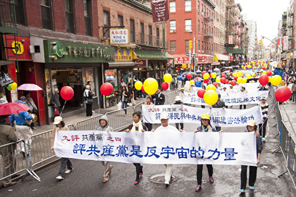 2013年5月18日，紐約曼哈頓，來自世界各地的法輪功學員舉行慶祝法輪大法弘傳21週年大遊行。圖為遊行隊伍中的第三主題「三退保平安」方陣，「評共產黨是反宇宙的力量」橫幅。（戴兵／大紀元）