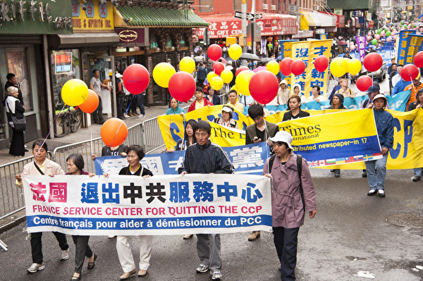 2013年5月18日，紐約曼哈頓，來自世界各地的法輪功學員舉行慶祝法輪大法弘傳21週年大遊行。圖為遊行隊伍中的第三主題「三退保平安」方陣，法國的「退出中共服務中心」橫幅。（戴兵／大紀元）