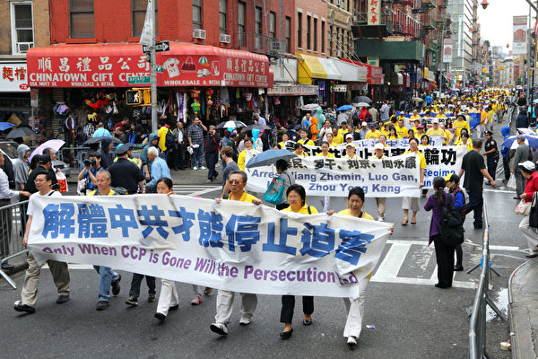 2013年5月18日，紐約曼哈頓，來自世界各地的法輪功學員在此舉行慶祝法輪大法弘傳21週年大遊行。圖為遊行隊伍中的「三退保平安」，「解體中共才能停止迫害」的橫幅。（潘在殊／大紀元）